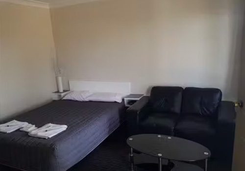 Blayney Goldfields Motor Inn room with light beige walls and dark, possibly black, patterned carpeting.