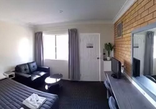A small Blayney Goldfields Motor Inn room with light beige walls and a dark carpet.